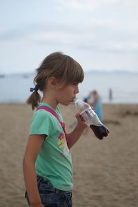 Full length of girl drinking coke on beach