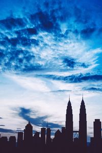 Low angle view of buildings against cloudy sky