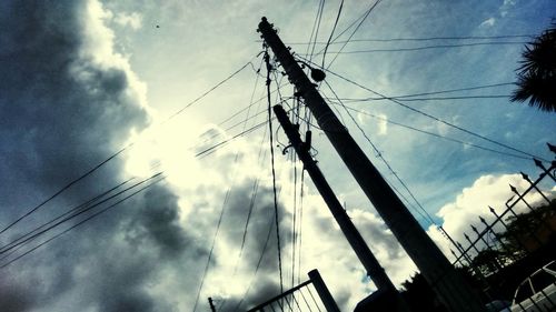 Low angle view of silhouette electricity pylon against sky