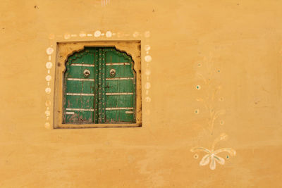 Close-up of closed window of old building