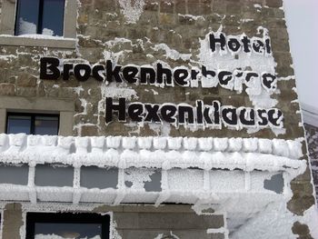 Close-up of text on snow covered brick wall