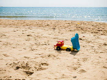 Toy toys on beach against sky