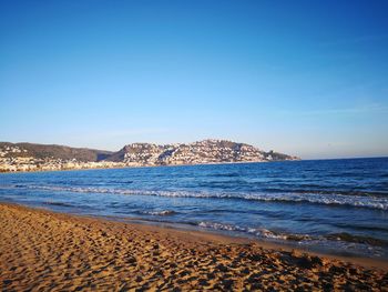 Scenic view of beach against clear blue sky