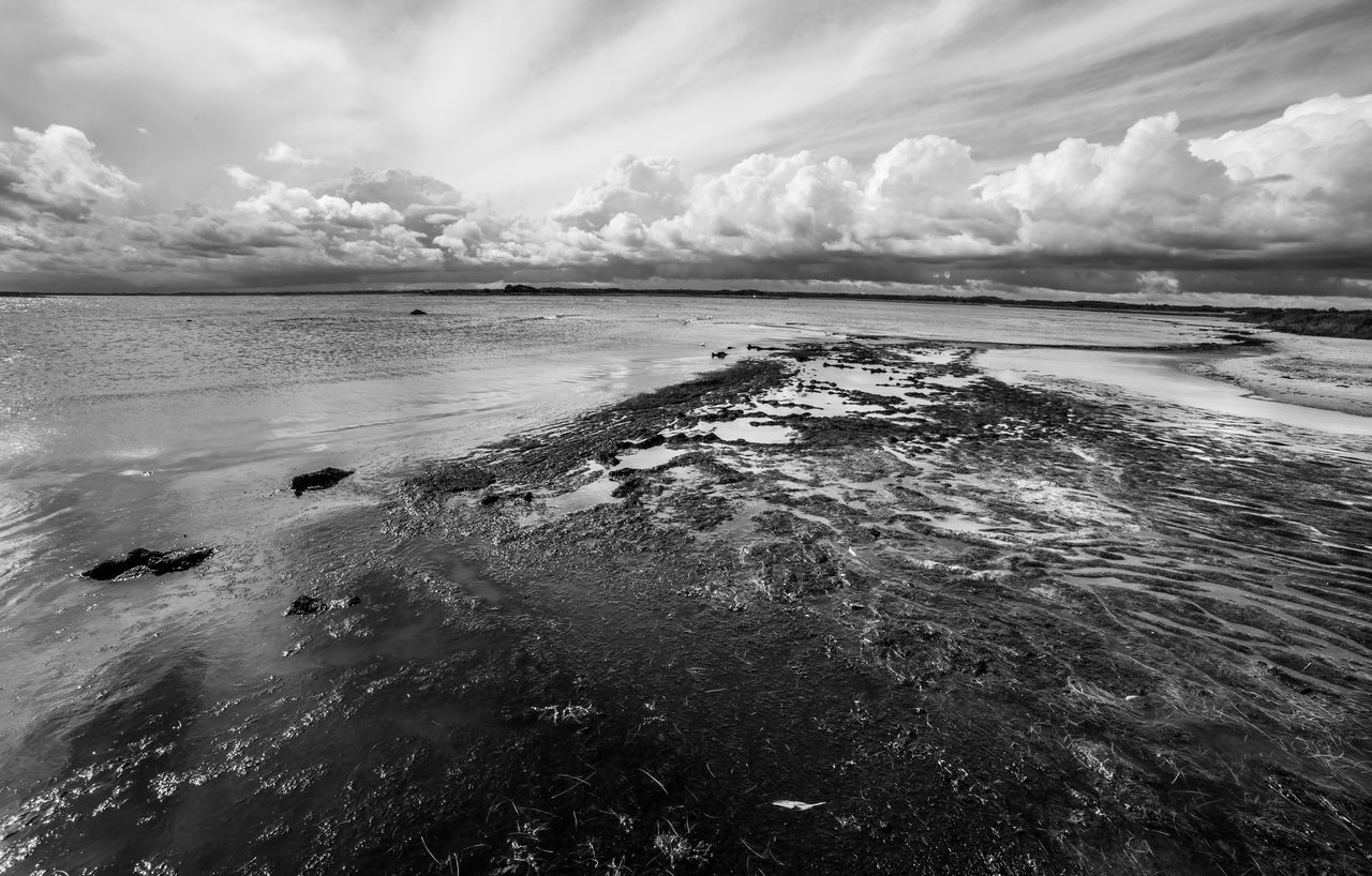 VIEW OF CALM BEACH AGAINST CLOUDS