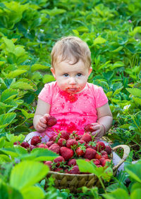 Portrait of cute baby girl standing amidst plants