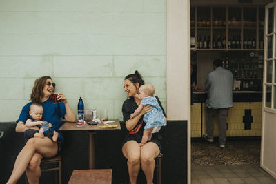 Mothers with babies relaxing in sidewalk cafe