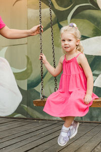 Portrait of cute girl sitting on swing