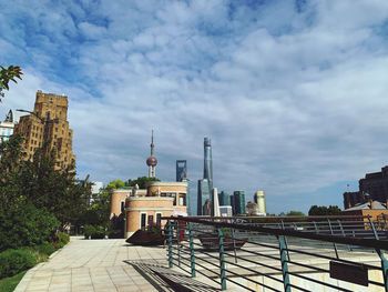 Buildings in city against cloudy sky