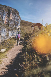 Young tourist walks on a path to the mountain. adventure travel, hiking concept.