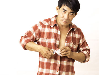 Portrait of man standing against white background