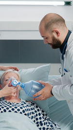 Side view of doctor examining patient in clinic