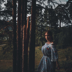 Rear view of woman standing in forest