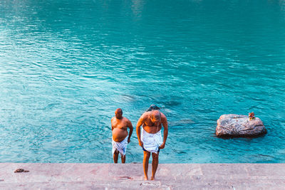 Rear view of two friends on sea shore