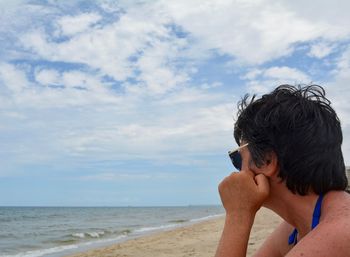 Portrait of boy on beach against sky