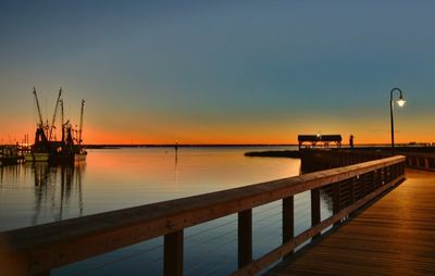 Pier on sea at sunset
