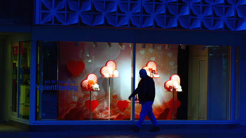 Full length of woman standing in illuminated building at night