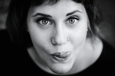 High angle portrait of young woman sticking out tongue