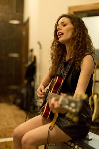 Young woman playing an electric guitar