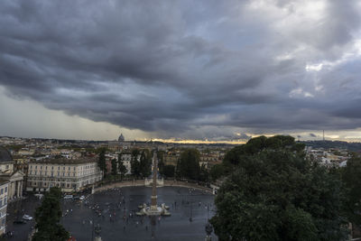 Aerial view of city against cloudy sky