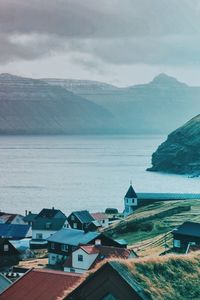 High angle view of houses by sea against sky