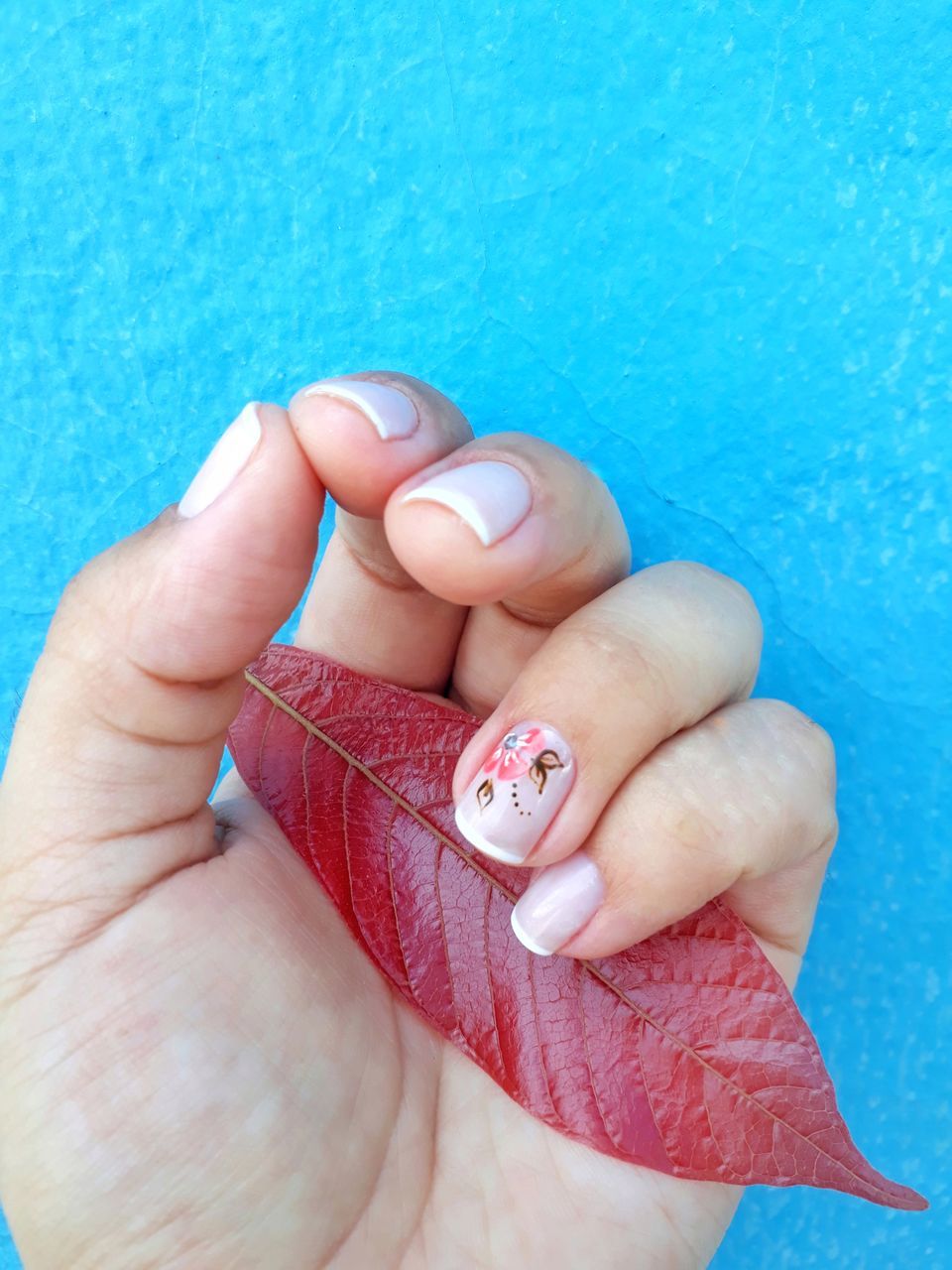 CLOSE-UP OF WOMAN HAND WITH BLUE TATTOO