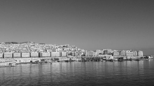 View of city by sea against clear sky