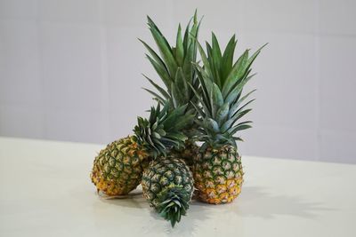 Close-up of fruits on table against wall