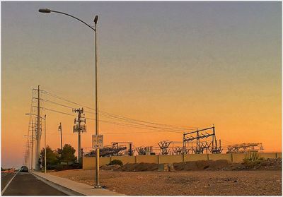 Electricity pylon against sky at sunset