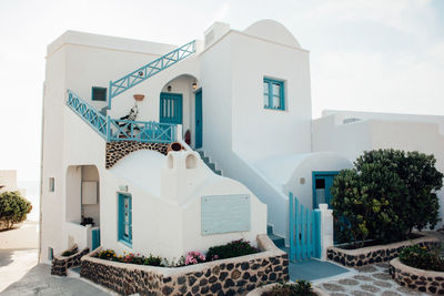 Exterior of houses by building against sky