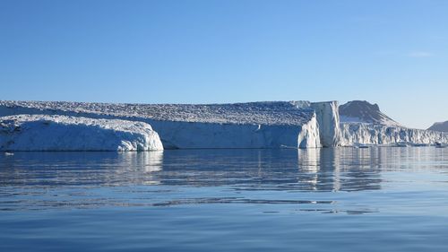 Scenic view of frozen lake against clear blue sky