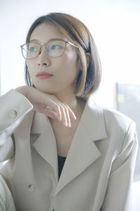 Portrait of young businesswoman standing against white background