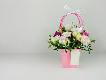 Close-up of flower vase on table against white wall