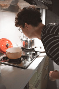 Side view of woman preparing food in kitchen