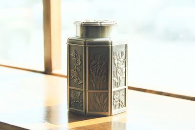 Close-up of floral carving on container by window