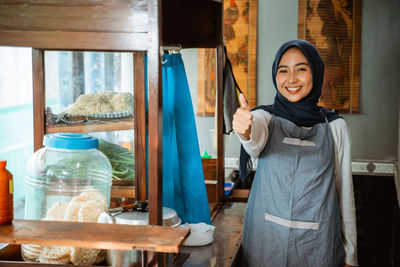 Portrait of smiling young woman standing at home