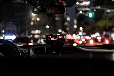 Cars on road in city seen through car windshield at night