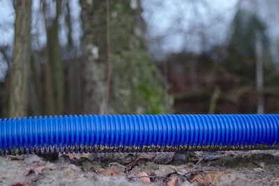 Close-up of pipe on field against trees in forest