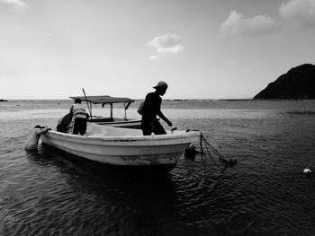 Men in boat on sea against sky