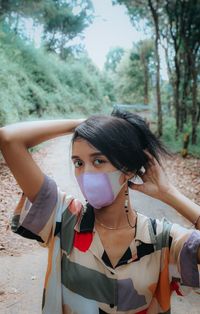 Portrait of young woman standing on land