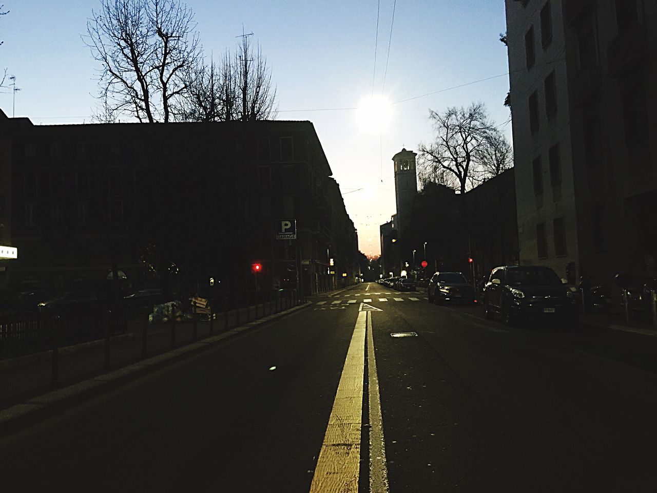 transportation, building exterior, the way forward, architecture, built structure, street, road, diminishing perspective, car, vanishing point, city, land vehicle, mode of transport, road marking, clear sky, sky, bare tree, city street, sunlight, sun