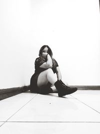 Portrait of woman sitting on tiled floor