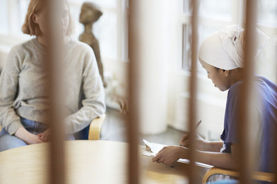 Female doctor talking to teenage patient and taking notes