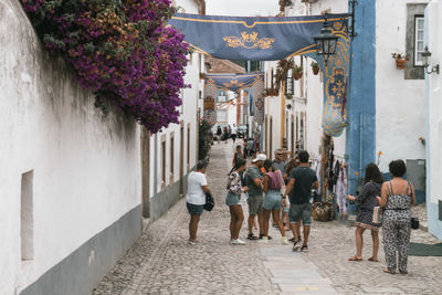 People walking on footpath amidst buildings