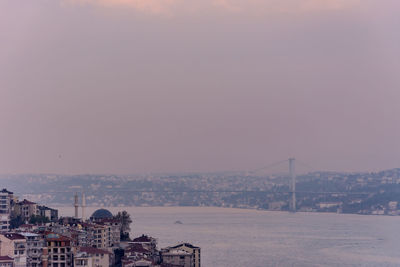 High angle view of townscape by sea against sky