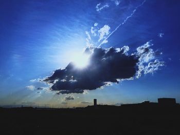 Silhouette of buildings against blue sky