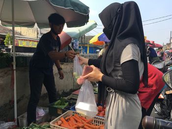 People at market stall in city