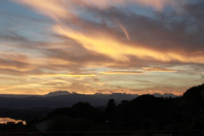 Scenic view of silhouette mountains against dramatic sky