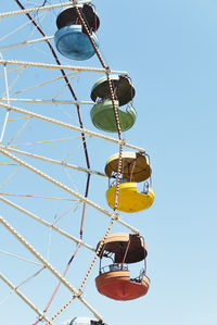 Low angle view of ferris wheel against clear blue sky