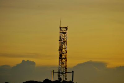 Low angle view of electricity pylon against sky during sunset