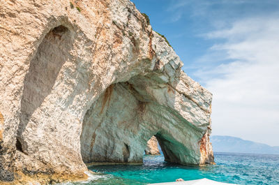 Rock formation in sea against sky